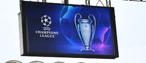 Logo a trofej UEFA Champions League zobrazená na veľkoplošnej obrazovke na štadióne San Siro v Miláne Logo a trofej UEFA Champions League zobrazená na veľkoplošnej obrazovke na štadióne San Siro v Miláne